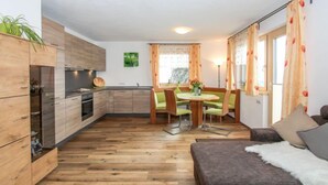 A compact living space with a kitchenette, dining area, and seating area. - Wildbachl by Interhome (Aschau im Zillertal)