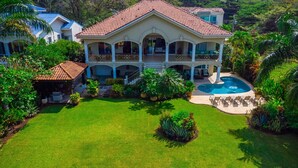 A large house with a swimming pool, surrounded by lush greenery and a well-maintained lawn. - Potrero Beachfront Villa with Pool & Private Chef - Casa Royal (Potrero)
