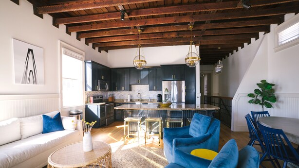 A modern kitchen with dark cabinets, a central island, and pendant lighting.