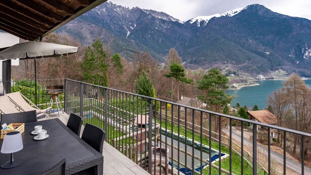 Un balcon avec vue sur les montagnes et un lac.
