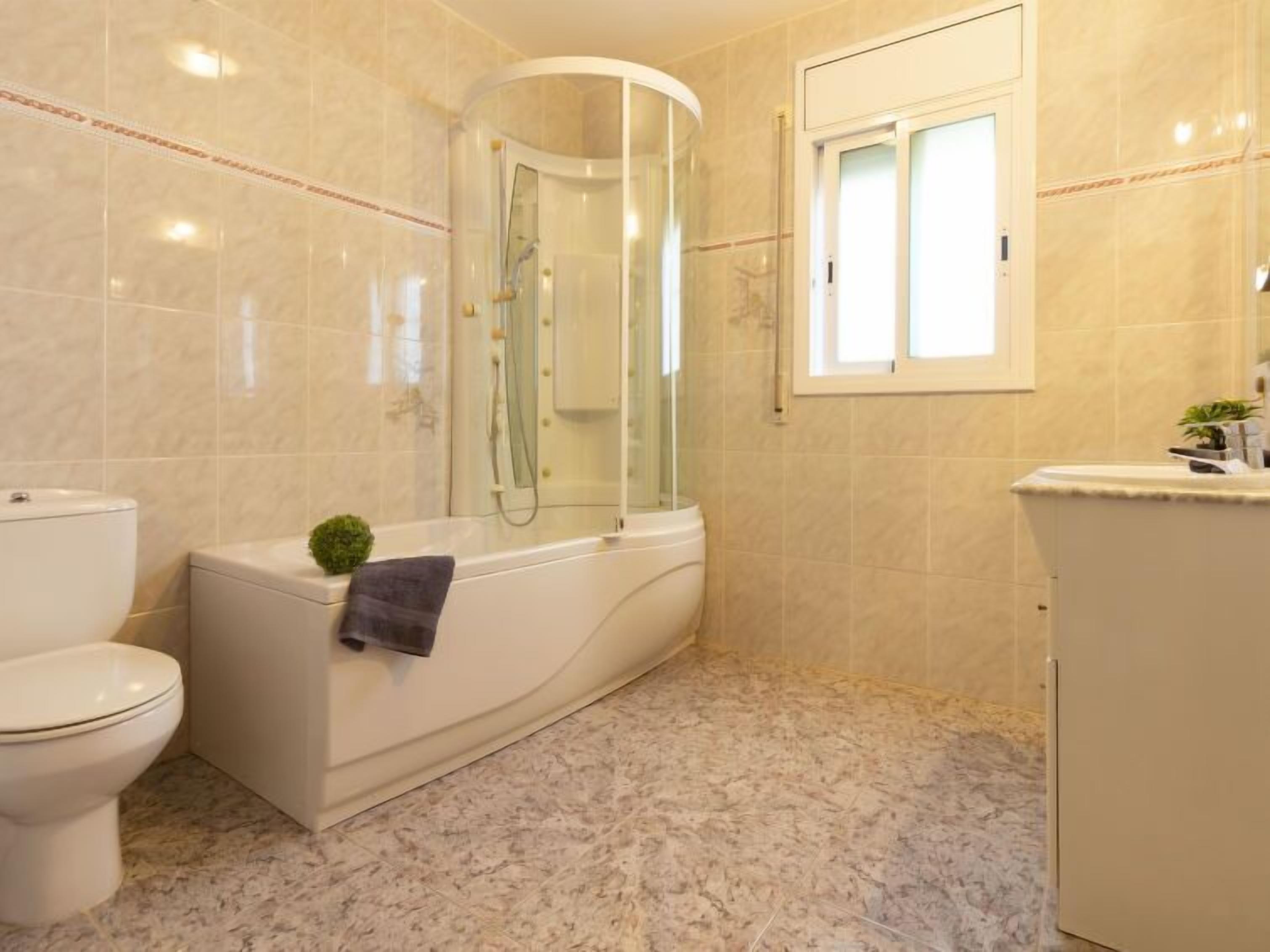 Un baño con inodoro, bañera y cabina de ducha.