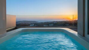 Un bain à remous offrant une vue dégagée sur un coucher de soleil se profilant à l’horizon.