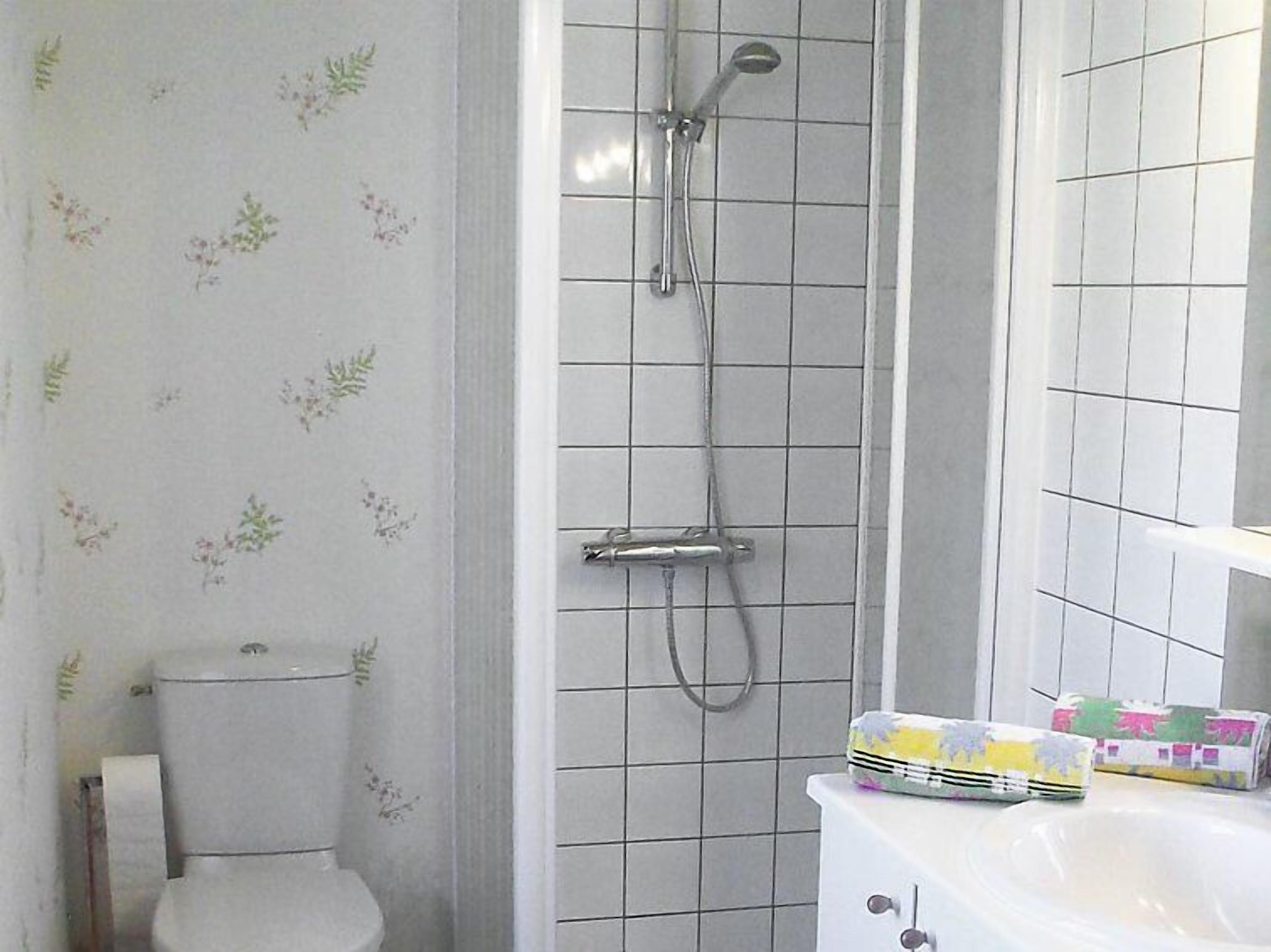 A bathroom with a shower, toilet, and sink.