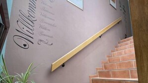 A staircase with a wooden handrail and a wall with a welcome sign. - Eifelhome One nahe Nürburgring by Interhome (Antweiler)