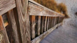 A wooden boardwalk leading to a beach with a clear view of the ocean.