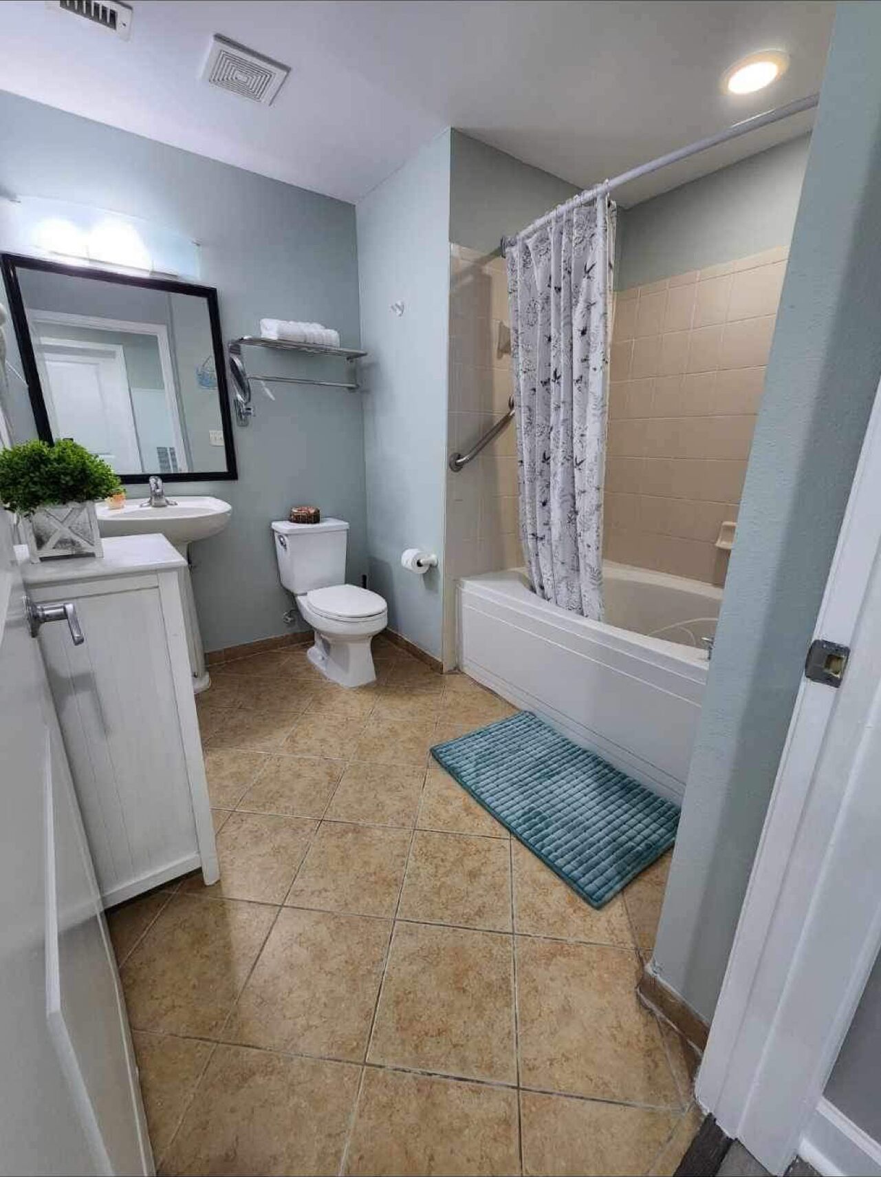 A bathroom with a toilet, sink, and shower area.