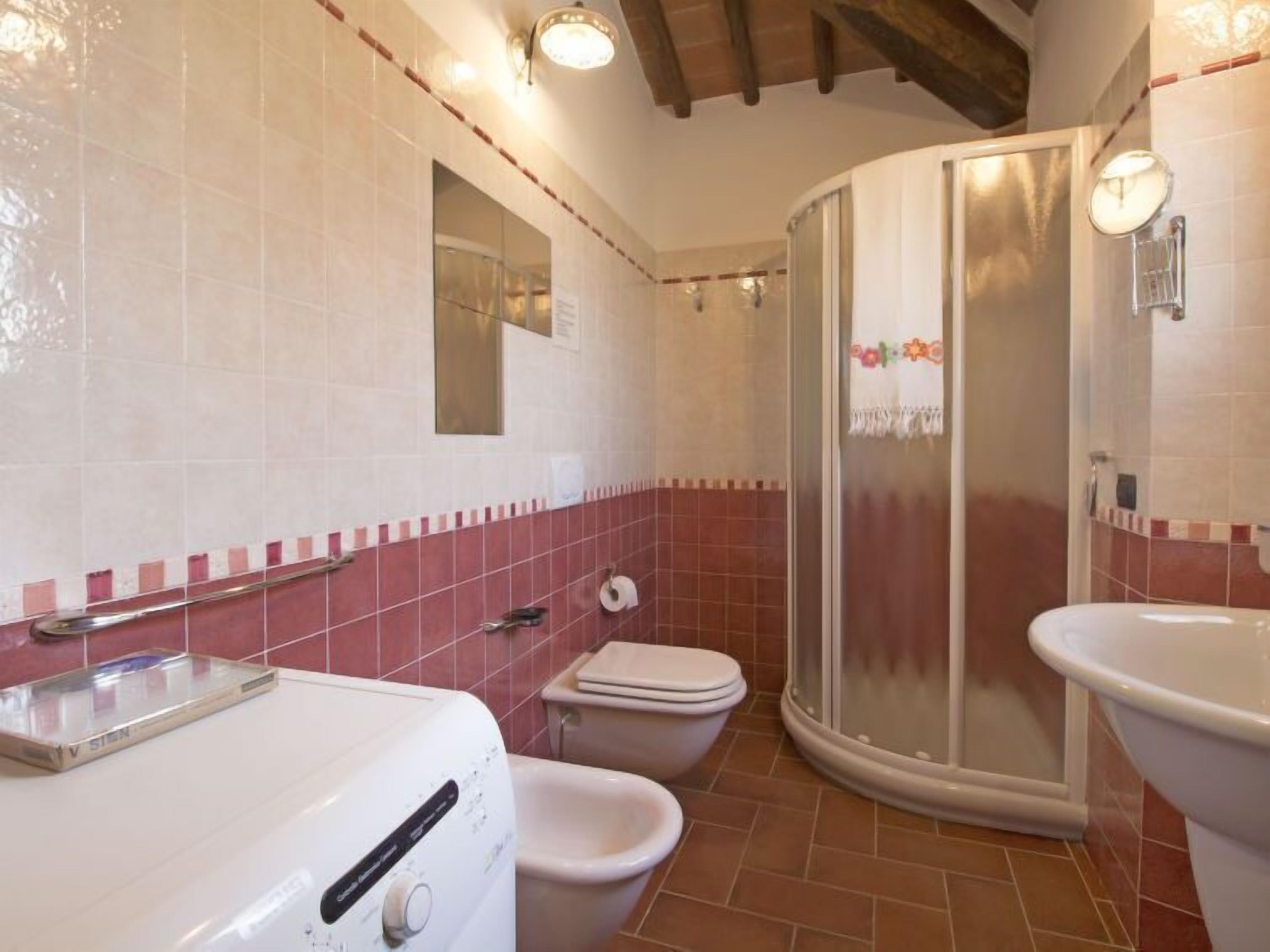 Un bagno con doccia, WC e lavandino.