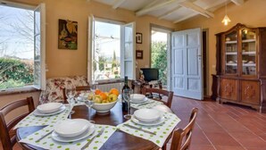 A dining area with a table set for four, a television, and a cabinet. - Il Fienile del Colle by Interhome (Pescia)