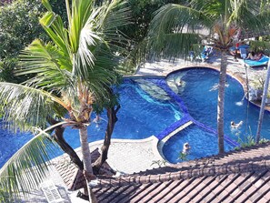 Una piscina al aire libre, sillones reclinables de piscina