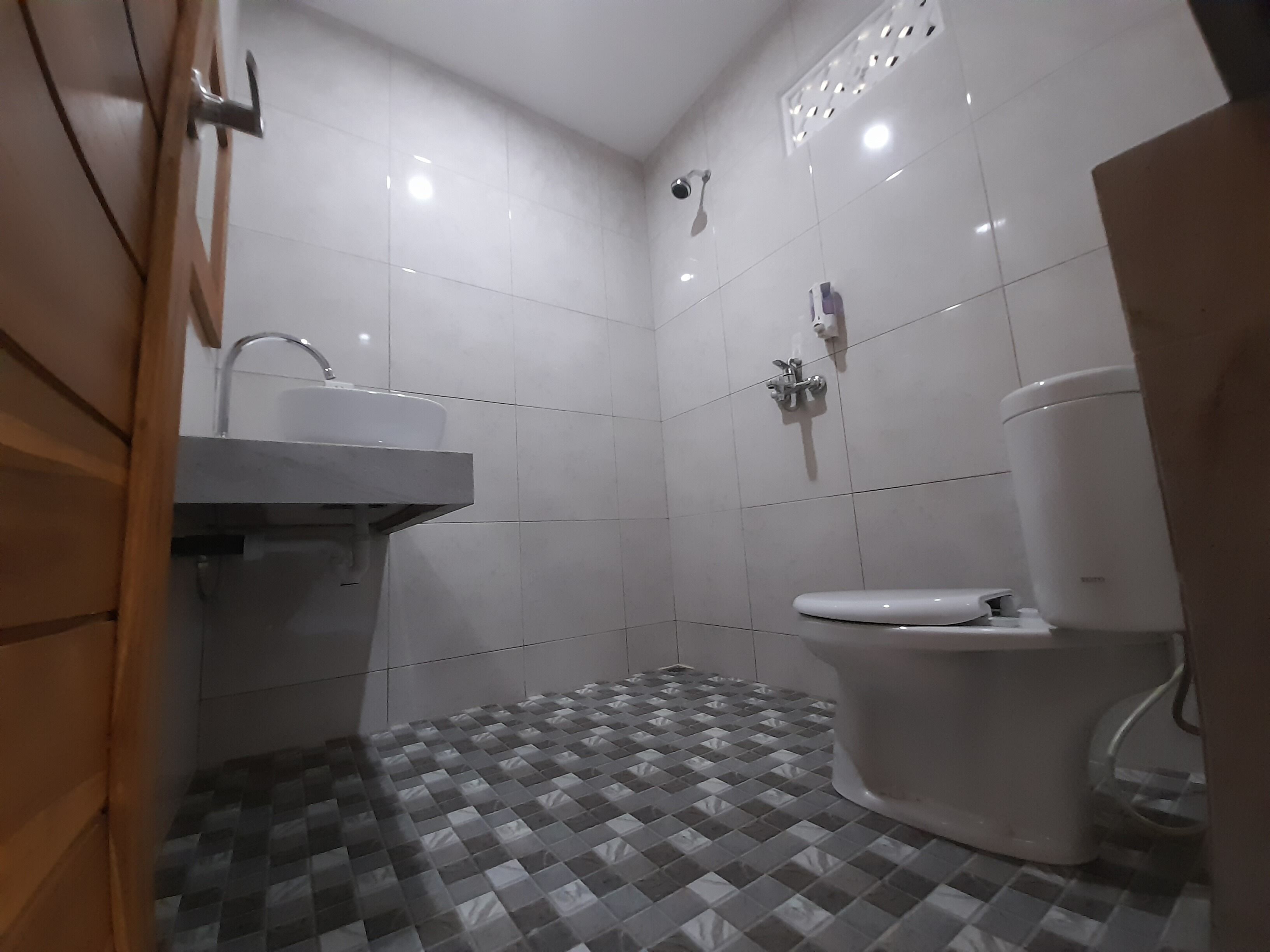 Un baño pequeño y moderno con inodoro, lavamanos y ducha.