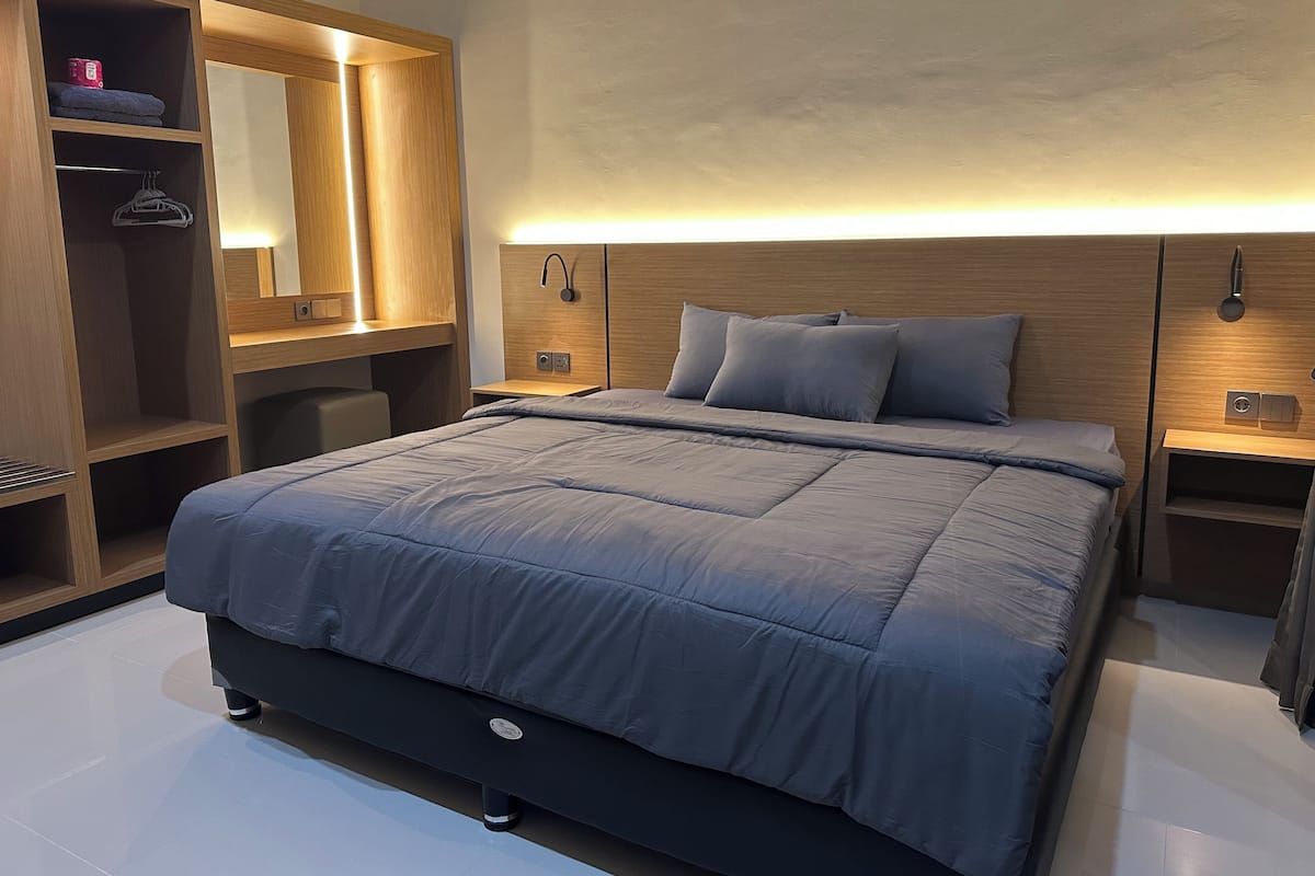 A modern bedroom with a bed, a wardrobe, a bedside table, and a nightstand.