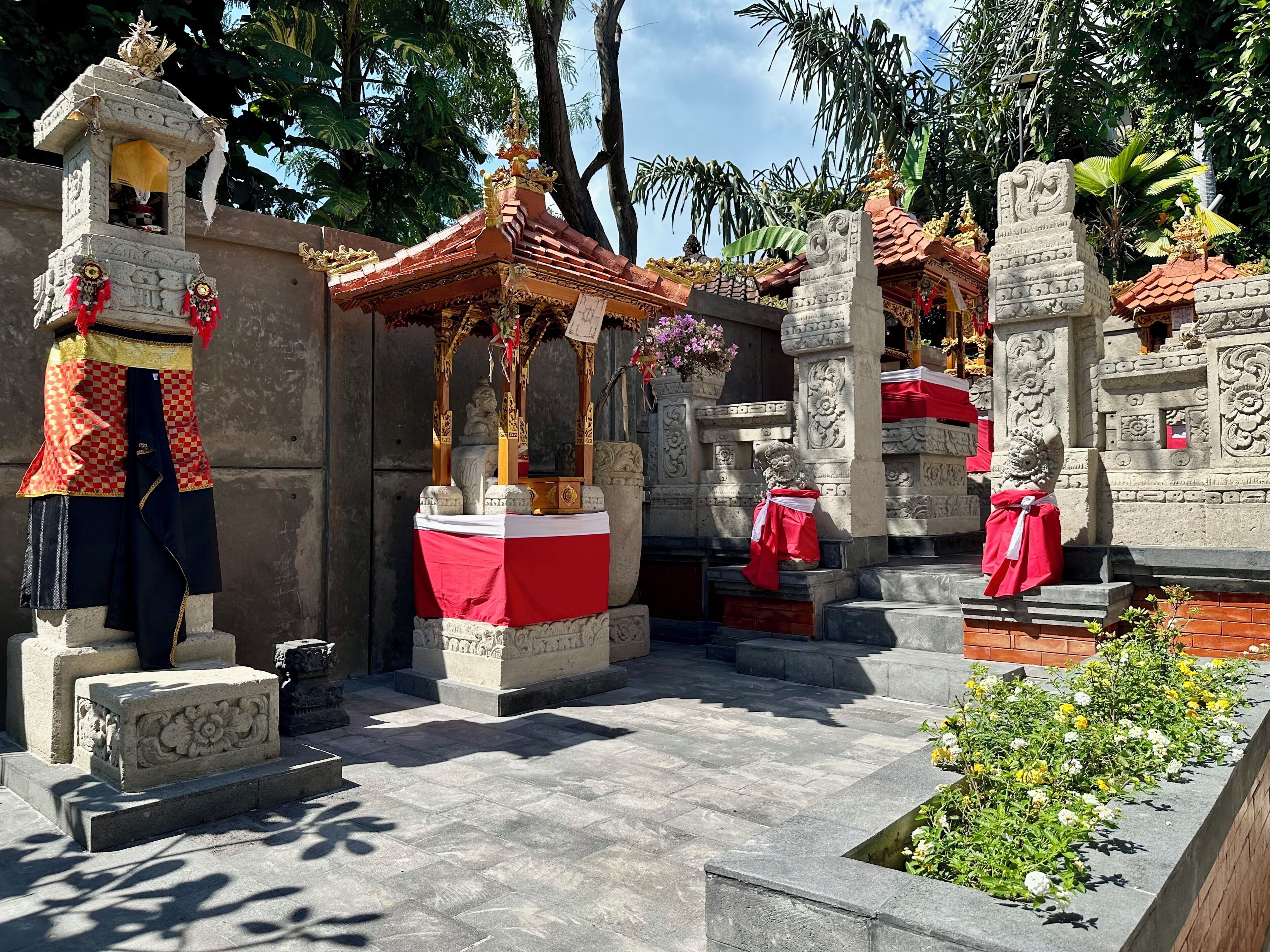 A temple with stone statues, a shrine, and a small garden area.