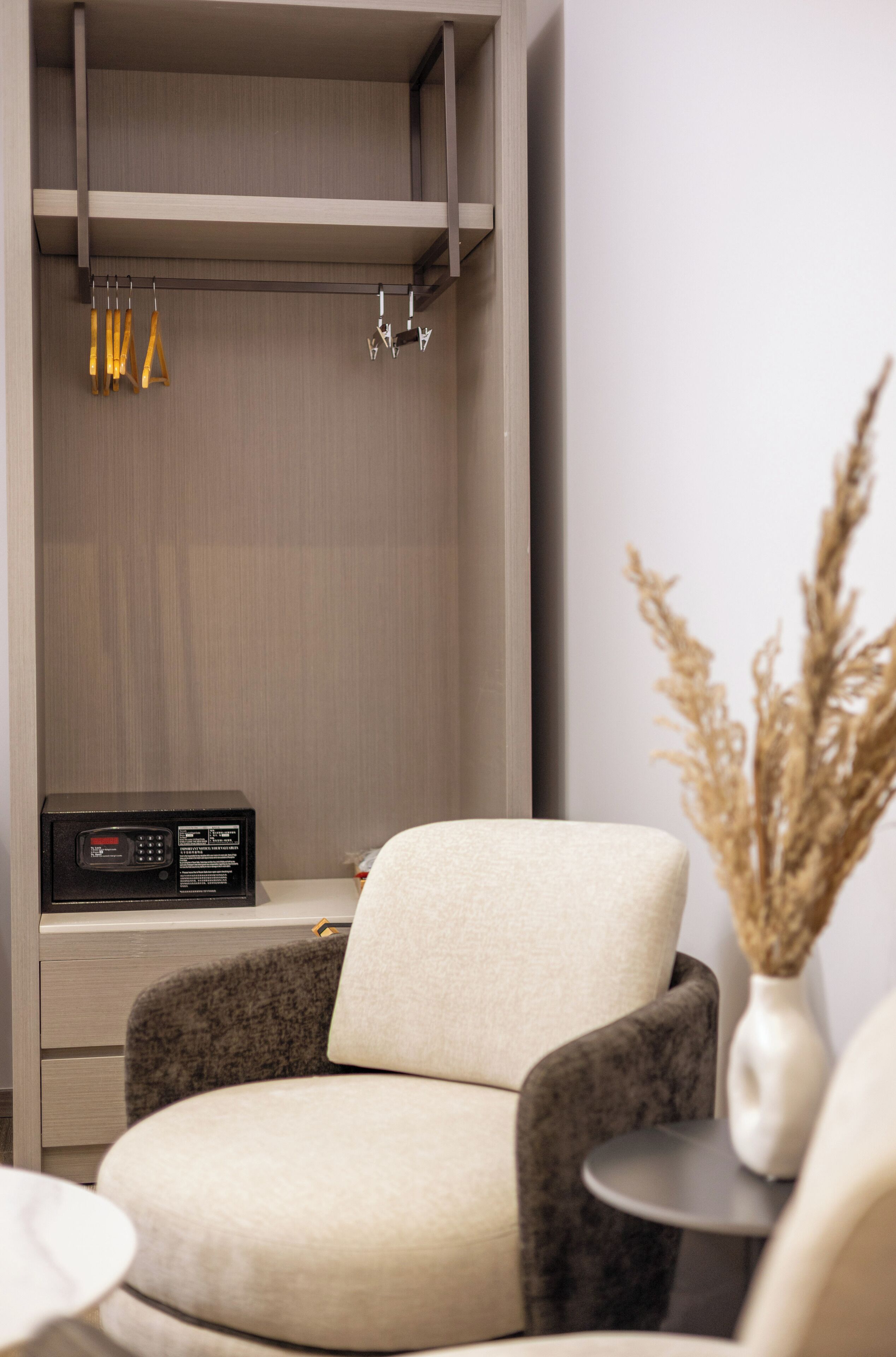 A modern room with a grey sofa, a small round table, and a microwave on a wooden cabinet.