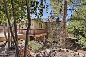 A two-story house with a balcony, surrounded by trees and a stone wall. - Wooded Patio Oasis! Group Getaway in Flagstaff (Flagstaff)
