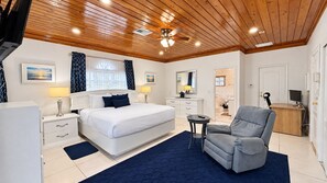 A hotel room with a large bed, a desk, a chair, and a ceiling fan. - 5-Minute Walk to Saunders Beach, restaurants, attractions and public transport (Nassau)