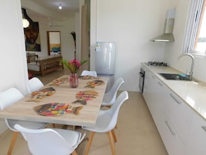 A modern kitchen with white cabinetry, a stainless steel refrigerator, and a gas stove.