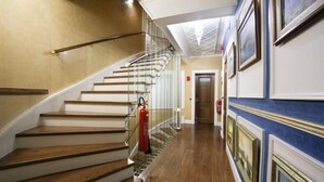 A wooden staircase with glass railings, a fire extinguisher, and framed pictures on the wall. - Medar Hotel (Istanbul)