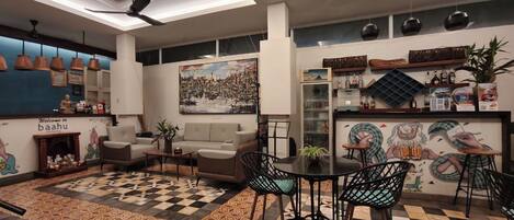 A modern interior with a checkered floor, a sofa, a dining table with chairs, ceiling fans, and a wall with a cityscape painting.