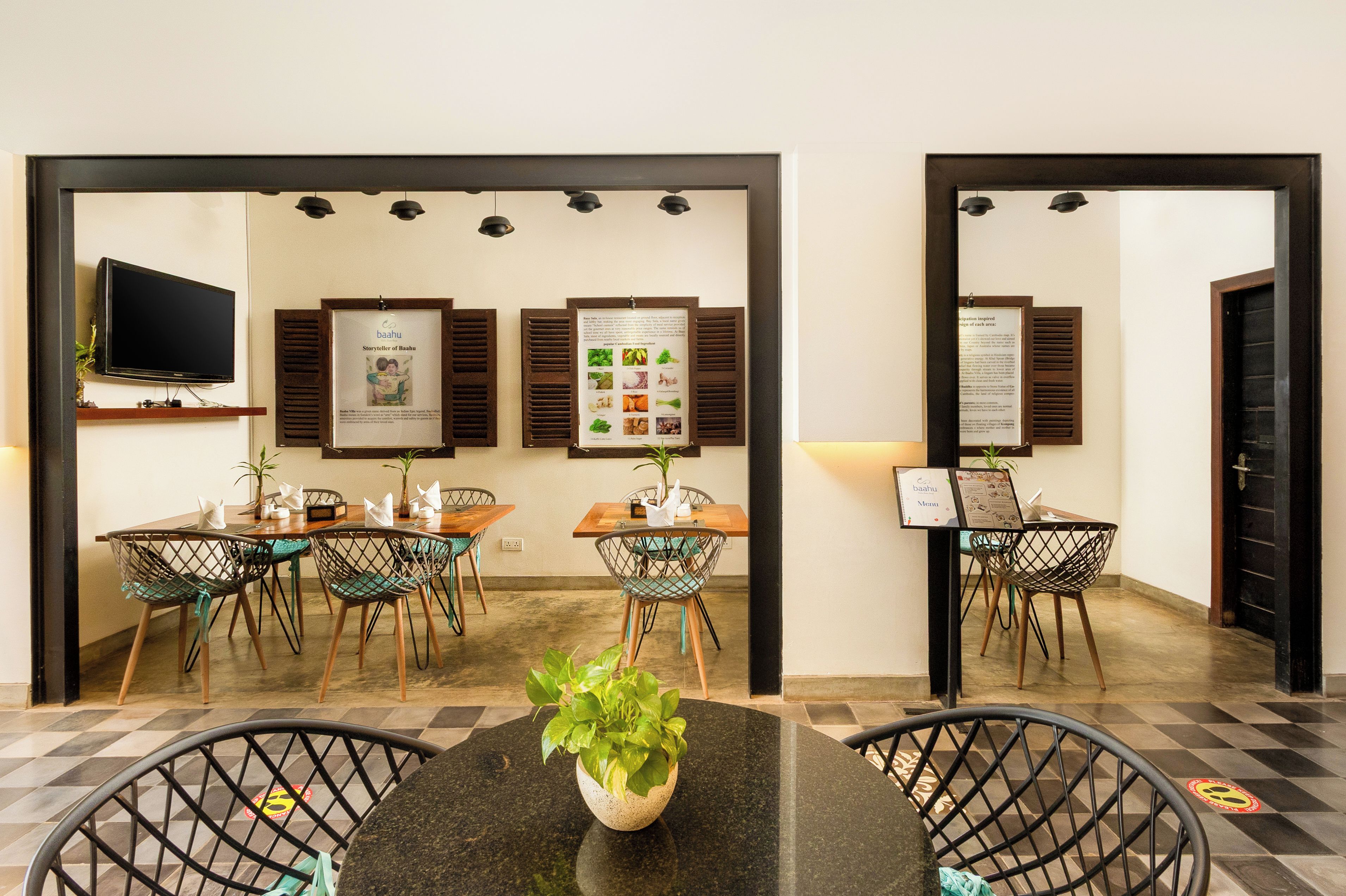 A hotel reception area with a check-in counter, seating arrangements, and informational posters on the wall.