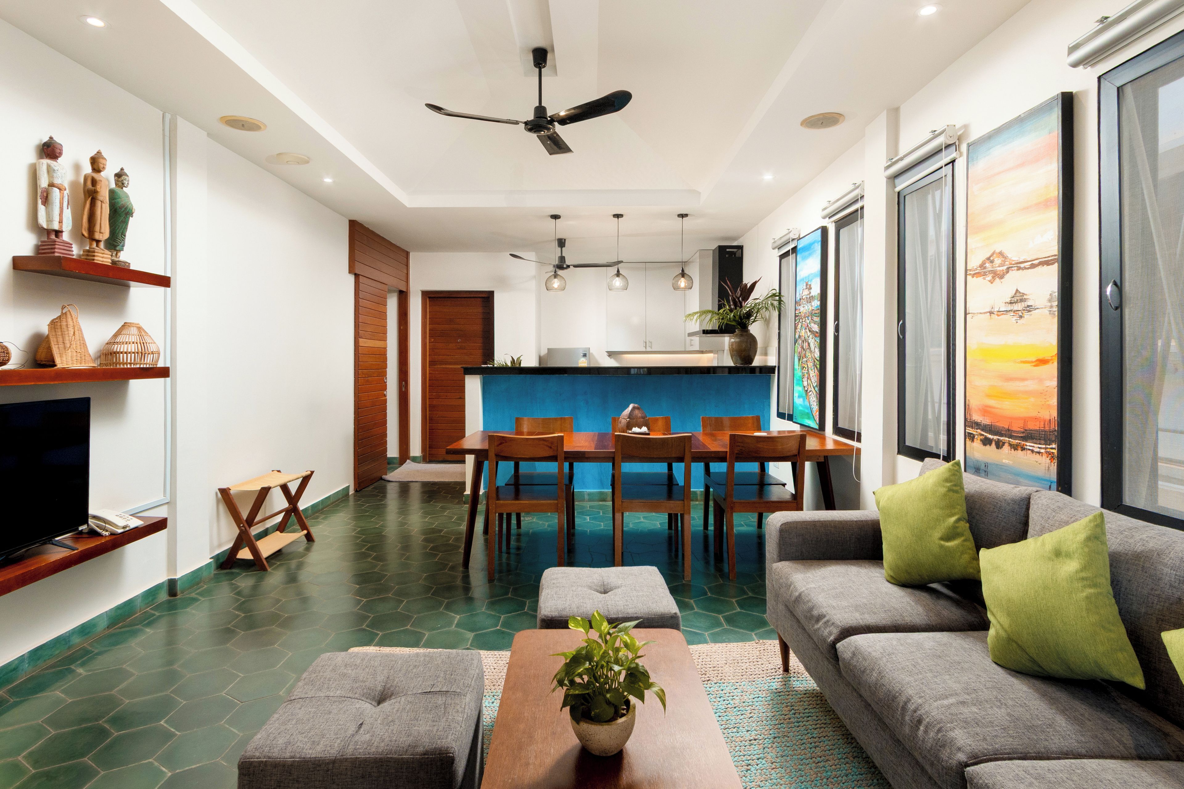 Un salon moderne comprenant un canapé, une table basse et un coin repas avec des chaises.
