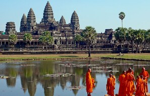 A temple complex with multiple towers and a reflection in the water. - Baahu Villa (Siem Reap)