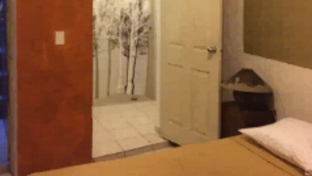Une chambre à coucher avec un lit, une porte donnant sur un balcon et un tableau accroché au mur.
