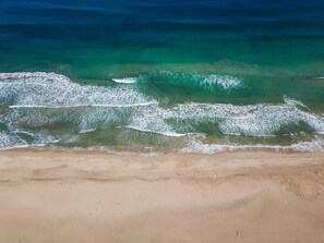 A beach with clear turquoise water and gentle waves. - Dream Vintage Surf Cottage TVNC 4301 (Hanalei)