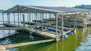 A dock with a covered walkway, boats, and a ladder.