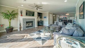 A living room with a fireplace, a sofa set, a coffee table, and a large plant.