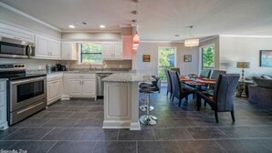A modern kitchen with white cabinetry, a granite countertop, and a central island.