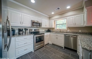 Enjoy cooking in this well-equipped kitchen with a refrigerator, microwave, oven, and dishwasher.