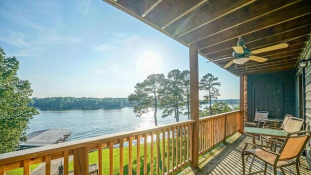 A wooden deck with a view of a lake and trees.