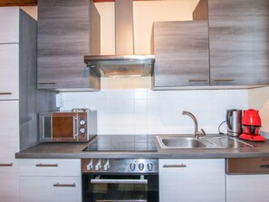 A modern kitchen with stainless steel appliances, a built-in oven, and a toaster.