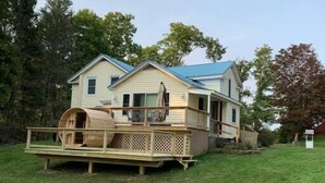 A two-story house with a deck and a covered porch.