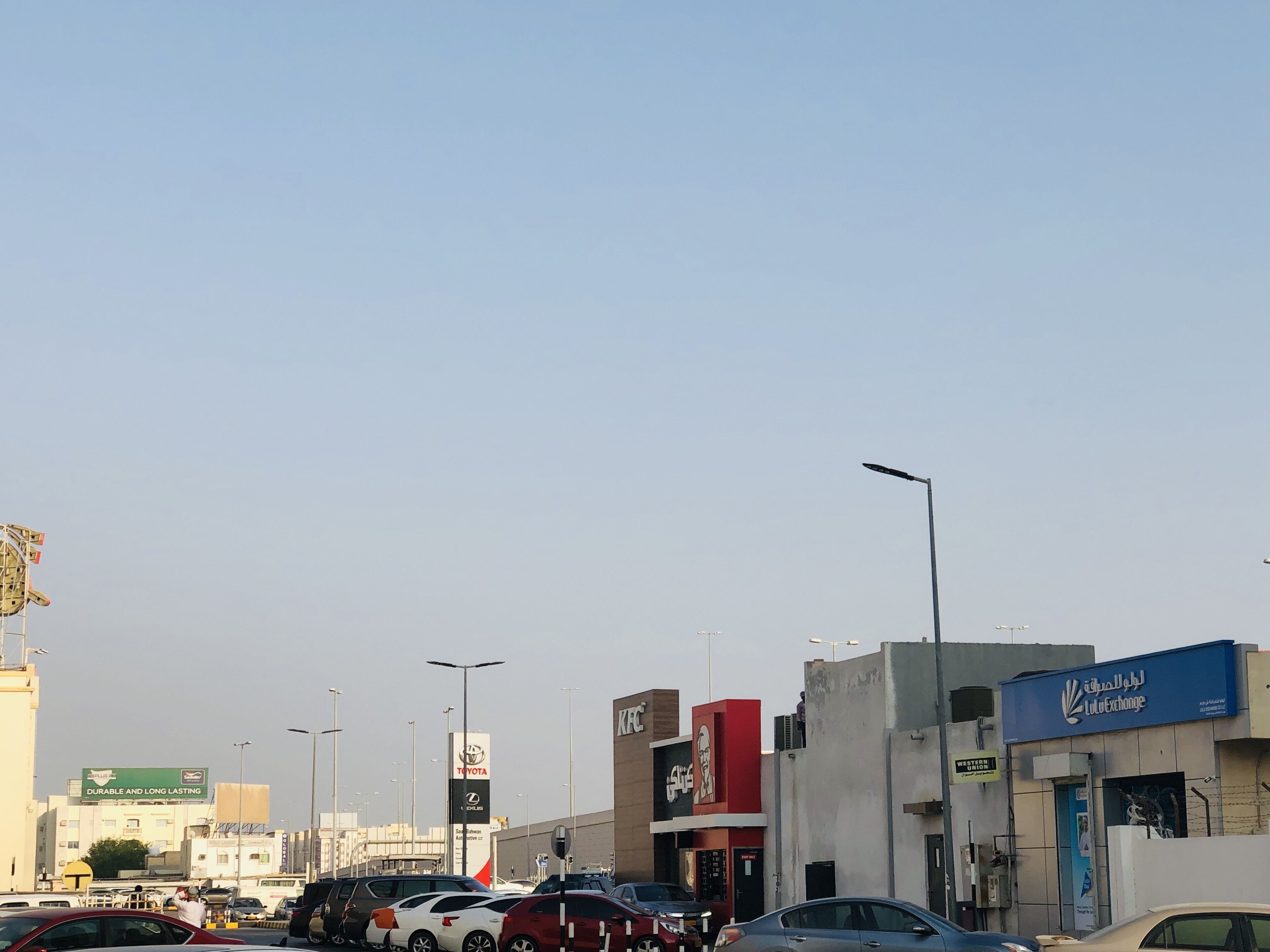 A busy urban street with various commercial buildings, including a visible KFC and a Toyota dealership.
