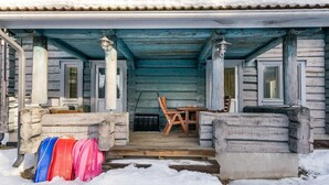 A wooden cabin with a covered porch, a dining table, and chairs. - Vesan villa by Interhome (Sysmä)