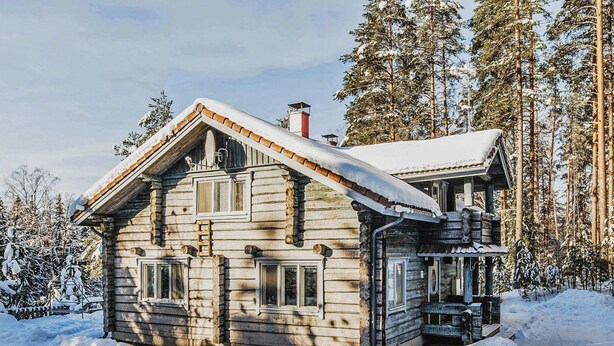 A log cabin with a snow-covered roof, a chimney, and a porch with a railing. - Vesan villa by Interhome (Sysmä)