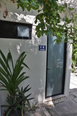 Un edificio con puerta de vidrio y un letrero que indica el baño de hombres.