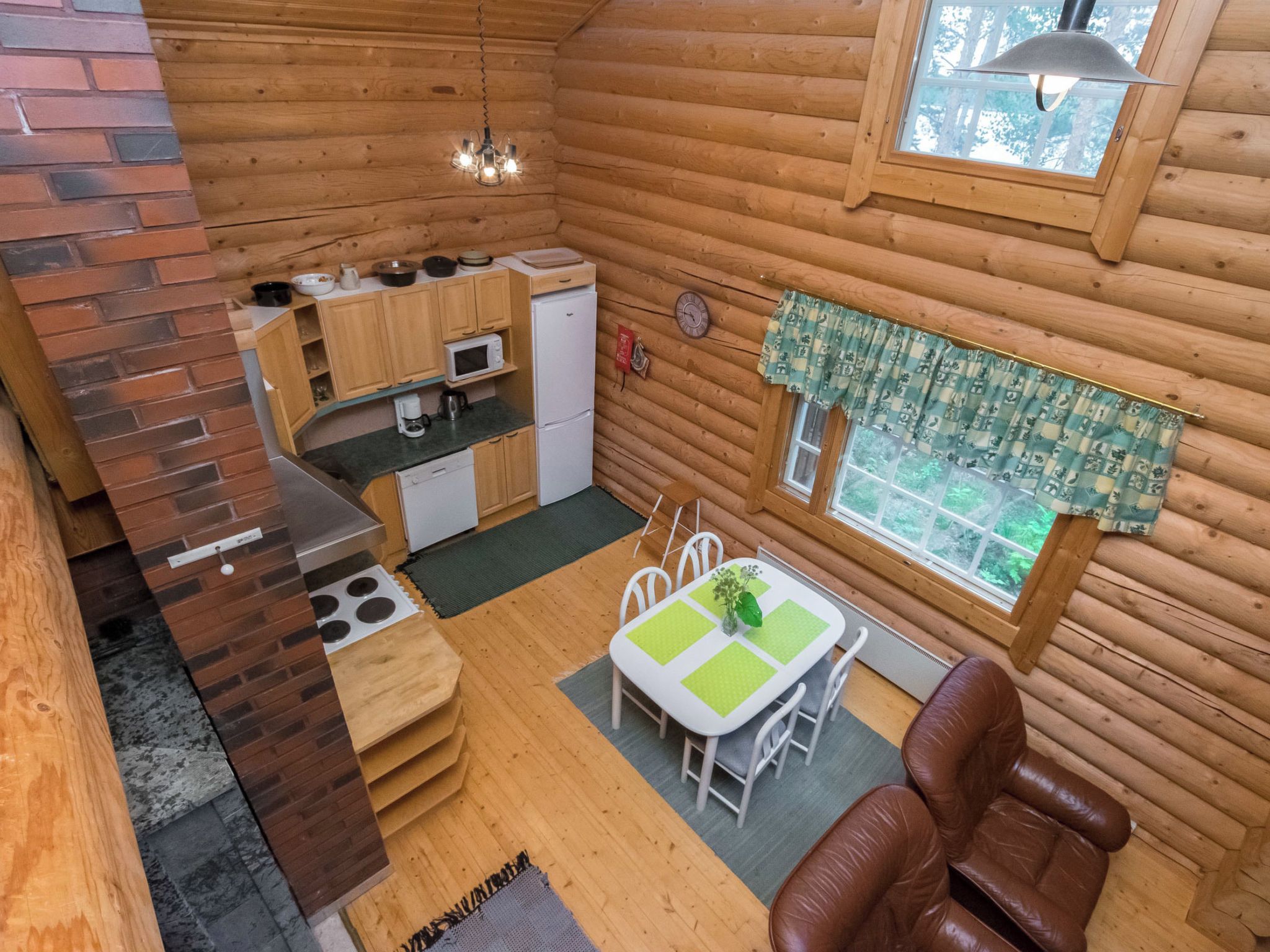 Eine kompakte Holzhütte mit Küche, Essbereich und einer gemütlichen Sitzecke.