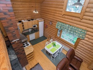 A compact wooden cabin with a kitchen, dining area, and a cozy seating space. - Neitlinna by Interhome (Mikkeli)