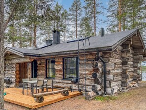 A log cabin with a deck, outdoor seating, and a view of a lake. - Harjula by Interhome (Kuusamo)