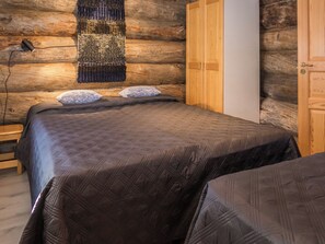 A log cabin bedroom with a bed, a bench, and a wardrobe. - Harjula by Interhome (Kuusamo)