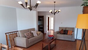 A spacious living room with two sofas, a wooden coffee table, and a dining table. - Wonderful villa composed of 3 bedrooms with wardrobes, 2 complete bathrooms. (Foz do Arelho)