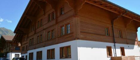 A large wooden building with multiple windows and a sloped roof, likely a hotel or public building.