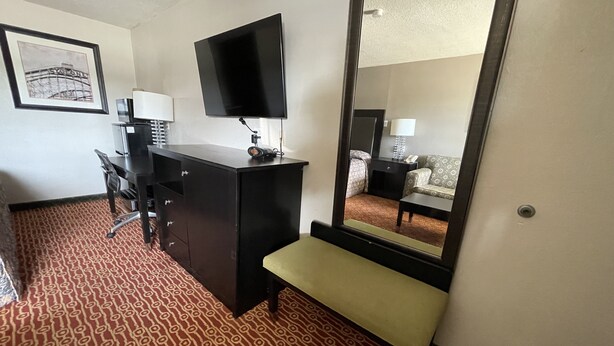 Une chambre d’hôtel équipée d’un bureau, d’une chaise et d’un grand miroir.