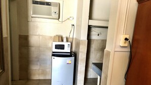 Une petite cuisine équipée comprenant un réfrigérateur, un four à micro-ondes et un petit plan de travail.