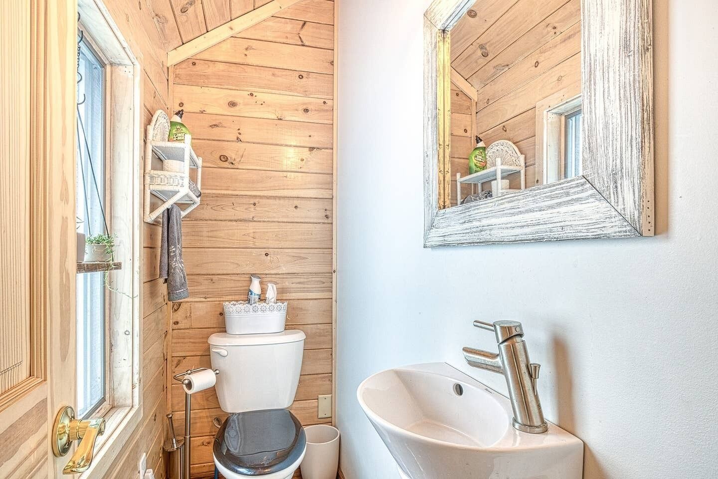 Un bagno piccolo ma funzionale, con il water, il lavandino e uno specchio.
