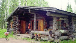 A log cabin with a porch, wooden doors, and a small garden area with potted plants. - Alppimaja by Interhome (Asikkala)