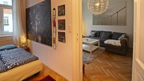 Ein modernes Wohnzimmer mit einer Couch, einem Couchtisch und einem großen abstrakten Gemälde an der Wand.