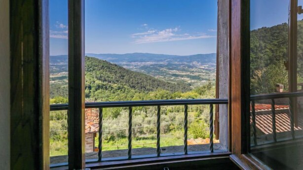 A room with a large window offering a view of a mountainous landscape. - La Torre by Interhome (Reggello)
